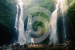 Amazing romantic view of happy couple near beautiful grand waterfall