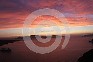 Amazing Santorini sunset, Greece. Colorful sky, blue crystal water, cruise ship