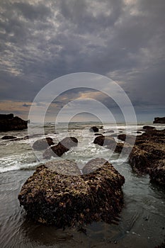 Amazing seascape for background. Beach with rocks and stones. Low tide. Motion water. Cloudy sky. Slow shutter speed. Soft focus.