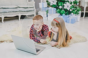 Amazing siblings buying christmas presents online with laptop together.