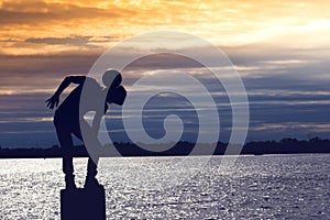 Amazing silhouette of football soccer player boy playing tricks on the beach