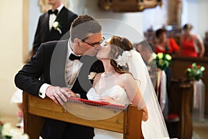 Amazing stylish cute groom and bride is kissing on the backgrou