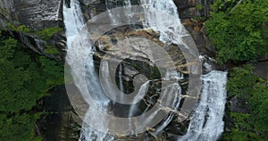 Amazing summer landscape with forest river waters falling down in big waterfall with clear water between rocky boulders