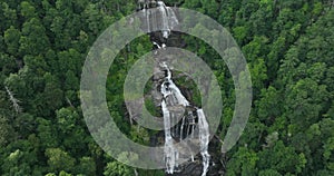 Amazing summer landscape with forest river waters falling down in big waterfall with clear water between rocky boulders