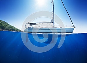 Amazing sunlight seaview to sailboat in tropical sea with deep blue underneath splitted by waterline