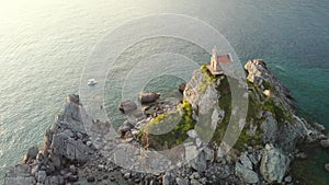 Amazing sunset aerial view from a drone of the tiny Church Sveta Nedjelja Island near Petrovac in Montenegro