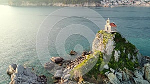 Amazing sunset aerial view from a drone of the tiny Church Sveta Nedjelja Island near Petrovac in Montenegro.