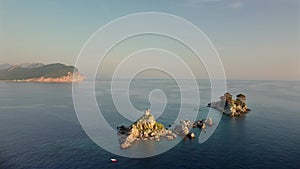 Amazing sunset aerial view from a drone of the tiny Church Sveta Nedjelja Island near Petrovac in Montenegro.