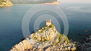 Amazing sunset aerial view from a drone of the tiny Church Sveta Nedjelja Island near Petrovac in Montenegro.