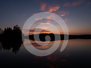 Amazing sunset, with beautiful sky reflections in the water of Hancza lake.