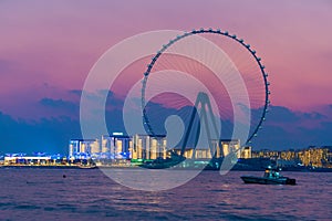 Amazing sunset colors over the sea view to the Ain Dubai, giant Ferris at Bluewaters Island close to JBR beach.