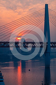 Amazing Sunset over bridge with moored boats in pier