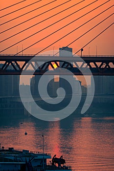 Amazing Sunset over bridge with moored boats in pier