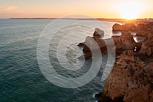 Amazing sunset over unique limestone rocks and secluded beaches near Alvor, Portugal