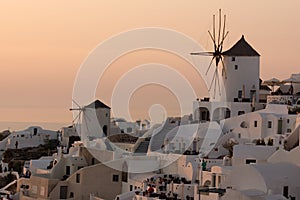 Amazing Sunset over white windmills in town of Oia and panorama to Santorini island, Cyclades, Greece