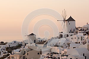 Amazing Sunset over white windmills in town of Oia and panorama to Santorini island, Thira, Greece