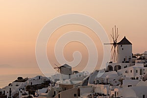 Amazing Sunset over white windmills in town of Oia and panorama to Santorini island, Thira, Greece