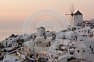 Amazing Sunset over white windmills in town of Oia and panorama to Santorini island, Thira, Greece