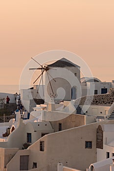 Amazing Sunset over white windmills in town of Oia and panorama to Santorini island, Thira, Greece