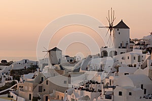 Amazing Sunset over white windmills in town of Oia and panorama to Santorini island, Thira, Greece