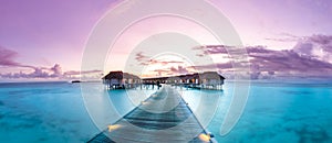 Amazing sunset panorama at Maldives. Luxury resort villas seascape with soft led lights under colorful sky