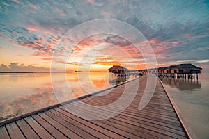 Amazing sunset panorama at Maldives. Luxury resort villas seascape with soft led lights under colorful sky. Beautiful twilight sky