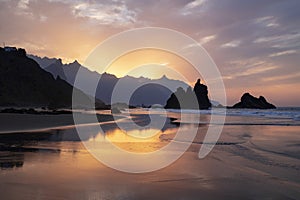 Amazing sunset with spectacular dramatic purple color sky reflecting into the water pools, Playa de Benijo, Tenerife