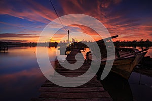 Amazing Sunset Twilight with wooden jetty and Abandon Old wreck on the shore