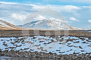 Amazing Tibetan landscape with snowy mountains and cloudy sky