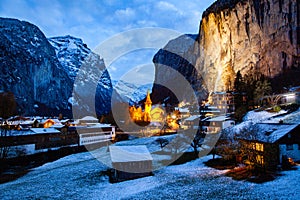 amazing touristic alpine village at night in winter with famous church and Staubbach waterfall  Lauterbrunnen  Switzerland  Europe