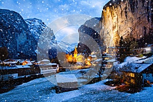 amazing touristic alpine village at night in winter with famous church and Staubbach waterfall  Lauterbrunnen  Switzerland  Europe