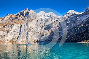 Amazing tourquise Oeschinnensee with waterfalls, wooden chalet and Swiss Alps, Berner Oberland, Switzerland