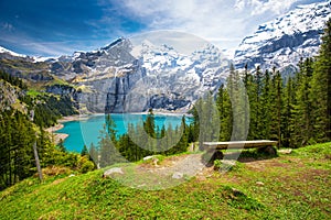 Amazing tourquise Oeschinnensee with waterfalls, wooden chalet and Swiss Alps, Berner Oberland, Switzerland