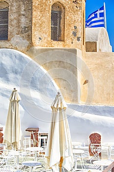 Amazing Travel Destinations. Open Air Caffee  in Oia Village on Santorini Island in Greece.  Old Pale Church on Background