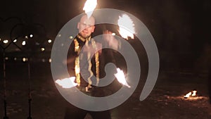 Amazing tribal fire show dance at night on winter under falling snow. Dance group performs with torch lights and