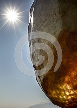Amazing and unique view of golden rock with sun and sunbeam in sky