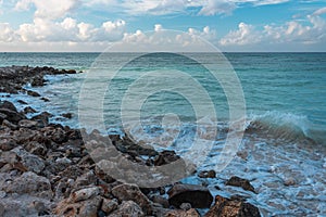 Amazing view of Aruba coast line. Turquoise water of Atlantic ocean merging with blue sky with white clouds.