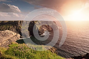 Amazing view on Cliff of Moher, county Clare, Ireland. Popular landmark with unparalleled scenery. Warm sunny day, Cloudy sky.