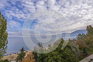 Amazing view on the green tree, mountains, sea with turquoise water and colorful blue sky at sunrise. Summer landscape