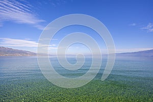 Amazing view on the green tree, mountains, sea with turquoise water and colorful blue sky at sunrise. Summer landscape