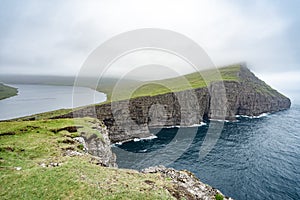 Amazing view of illusion lake on slave mountains of Tralanipan steep cliff in Vagar island, Faroe Islands, north Atlantic ocean, photo