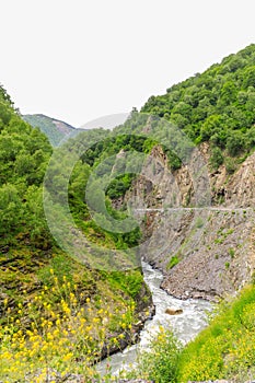 Amazing view of the landslide on a mountain road. mountain dirt road through the gorge along the mountain river Inguri