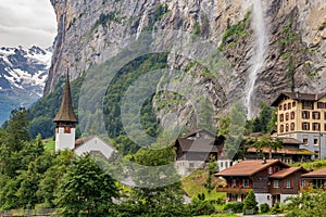 Amazing view of Lauterbrunnen town in Swiss Alps valley with beautiful Staubbach waterfalls in the background, Switzerland