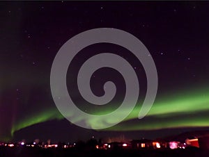 Amazing View of the Northern Lights Swirling over a Small Town of Reykjahlid in Northern Iceland