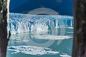 Amazing view of Perito Moreno glacier, blue iceberg glacier from peak of the mountain through the aqua blue lake in Los Glaciares