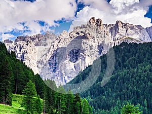 Amazing view of the rocky Dolomites mountains and the green woods of Trentino Alto Adige