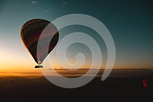 Amazing view of a vibrant colorful balloon at sunrise, flame firing to propel the balloon upwards. Balloon ride at luxor, egypt,