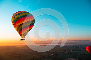 Amazing view of a vibrant colorful balloon at sunrise, flame firing to propel the balloon upwards. Balloon ride at luxor, egypt,