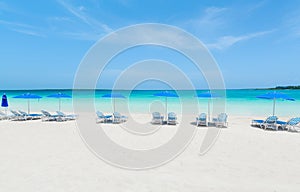 amazing view of a white sand beach and tranquil, turquoise ocean on blue sky background, sunny day