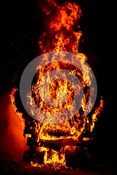 amazing violent bonfire of fire in a village in the dark night. The combustion of firewood creates big flames, flares, smoke, gas